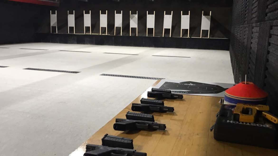 “Stand de tir avec pistolets alignés et cibles pour le cours confirmé pistolet.”