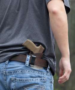 “Pistolet porté discrètement dans un holster à la ceinture, illustration pour le Cours Port d’Arme Discret.”