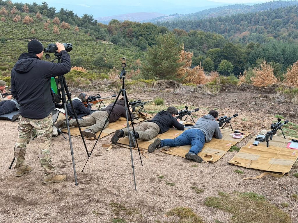 Participants allongés et observation du terrain pendant une séance de tir longue distance